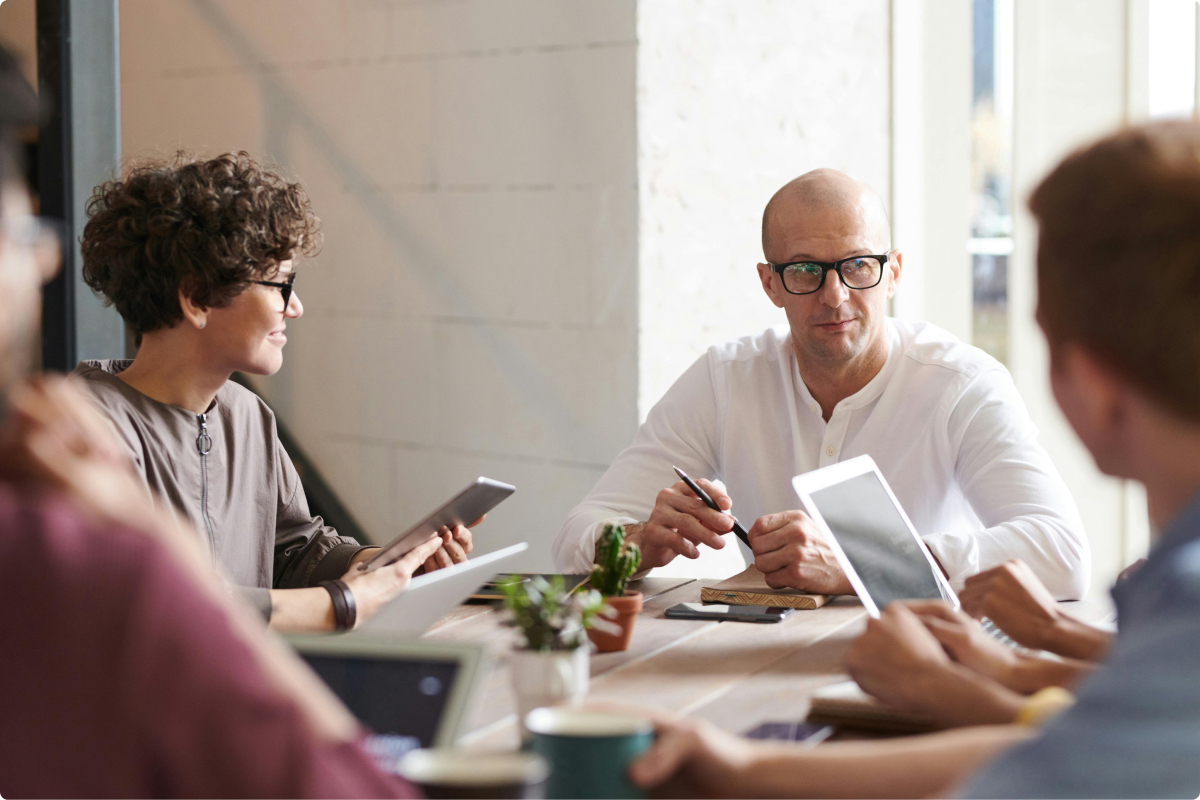 Agents collaborating around a table reviewing listings